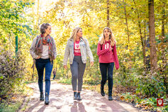 Three students walk through Dunn Woods.
